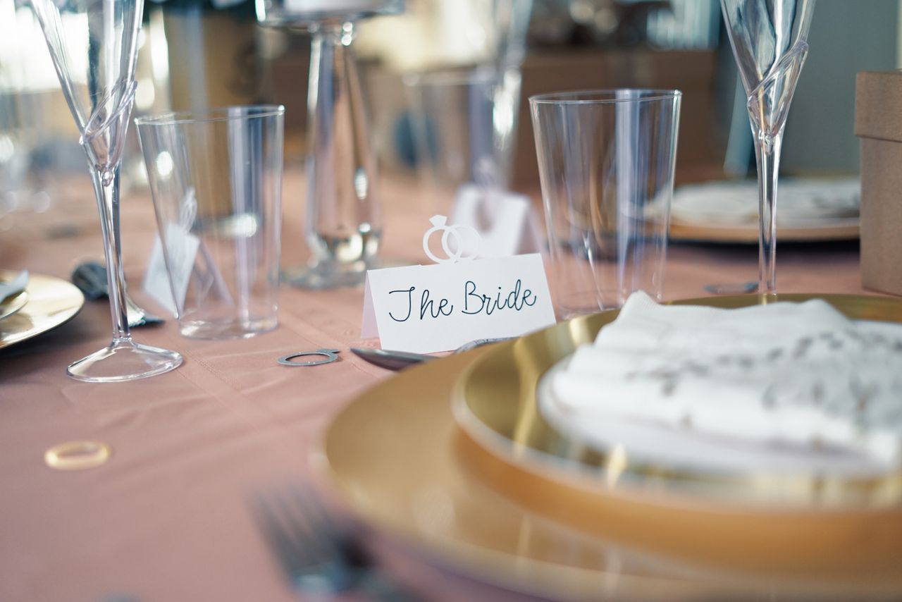 Luxurious wedding table setting with a 'The Bride' card and elegant glassware.